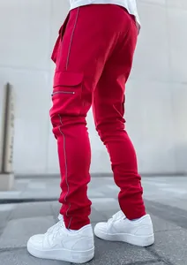 Detail view of red cargo pants for men featuring reflective stripes and multi-pockets