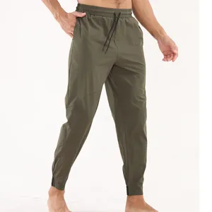 Gros plan d'un pantalon de sport olive pour hommes à séchage rapide pour entraînement actif.