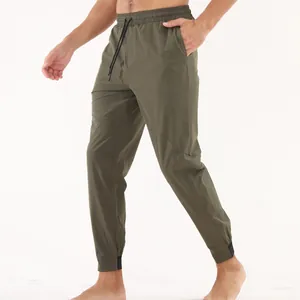 Détail du pantalon de jogging olive montrant la taille élastique et la texture