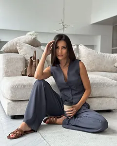 Detail shot of woman in dark grey sleeveless V-neck vest and wide-leg trouser suit