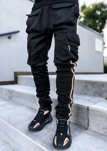 Men's black reflective cargo pants with multiple utility pockets on stone steps