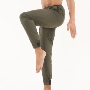 Vue détaillée d'un pantalon de sport à séchage rapide olive pour homme en plein mouvement.