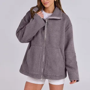 Dettaglio di una giacca in pile grigio oversize da donna con cerniera integrale.