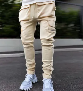 Close-up of men's beige cargo pants featuring reflective piping and multi-pocket design