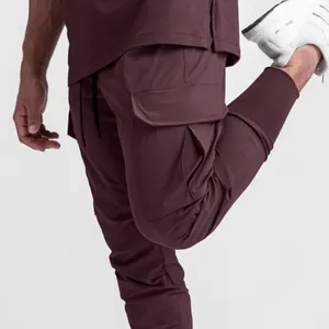 Detailed view of men's burgundy cargo joggers featuring side pocket and elastic cuffs