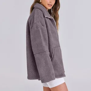 Dettaglio di una giacca oversize in pile teddy viola con collo alto e cerniera lampo.