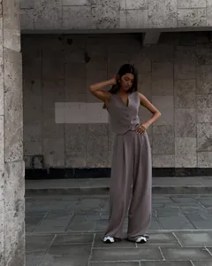 Lifestyle view of a chic mauve V-neck vest and matching wide-leg trousers suit set