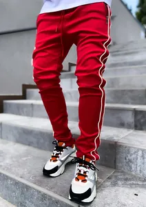 Men's red reflective stripe joggers with drawstring waist and zipper pocket details.