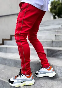 Detail view of men's red reflective cargo pants featuring side stripes on stairs