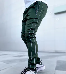 Close-up of men's dark green fitness pants featuring dual reflective side stripes