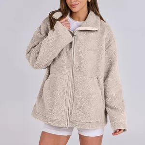 Dettaglio della giacca in pile sherpa beige da donna con collo alto e chiusura zip