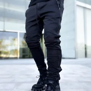 Slim fit men's black cargo pants featuring reflective piping and side zippers for sports