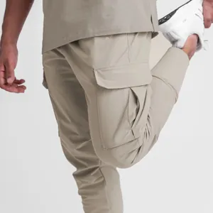 Close-up of men's khaki cargo joggers with multiple pockets and elastic cuffs.