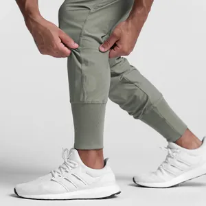 Close-up of men's stretch ice silk joggers highlighting fabric elasticity and ribbed cuffs.