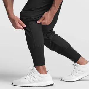 Close-up of black men's joggers showing elastic fabric texture and ribbed cuffs.