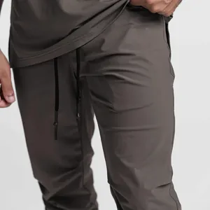 Close-up of men's dark grey fitness joggers featuring drawstring and ice silk fabric detail
