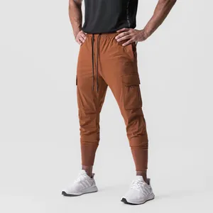 Men's rust orange cargo joggers with multi-pockets and drawstring waist for athletic wear