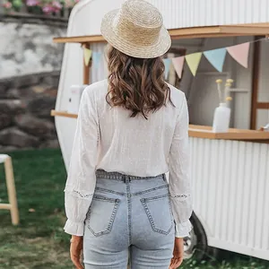Detailed back view of white cotton bell-sleeve shirt featuring delicate lace stitching embroidery