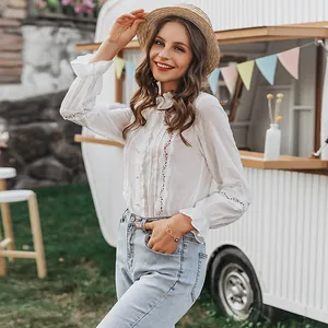 Elegant white cotton blouse detail featuring delicate lace inserts and textured Swiss dots