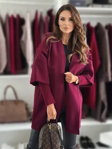 Detail view of a loose-fitting burgundy hooded coat styled with casual accessories.