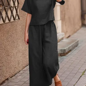 Detailed street style view of a woman wearing a black linen two-piece set outfit