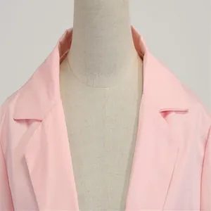Détail en gros plan du revers et du col d'une veste de blazer rose élégante pour femme