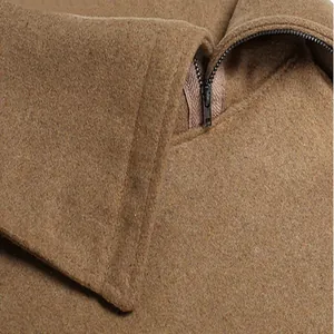 Dettaglio di un poncho in lana color cammello con zip e consistenza del tessuto