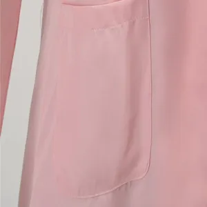Gros plan d'une grande poche plaquée sur une veste blazer rose unie pour femmes