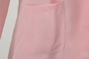 Close-up van de voorzak en de textuur van een roze blazer voor dames