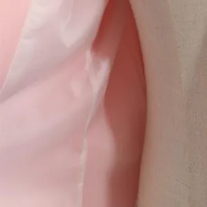 Gros plan sur la doublure intérieure rose lisse d'une veste de costume pour femme