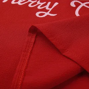 Macro detail showing the red fabric texture and quality stitching of Christmas top