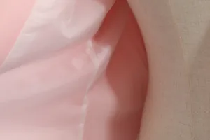 Detailopname van gladde roze binnenvoering en naad van een modieuze damesblazer