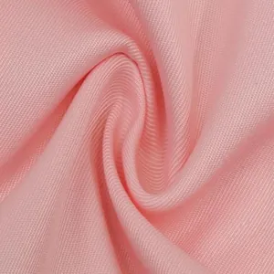 Gros plan du tissu d'un blazer rose montrant les détails de l'armure sergée texturée