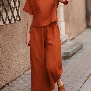 Women's burnt orange linen two-piece set featuring short sleeve top and wide-leg pants