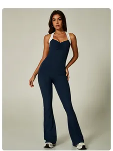 Full body view of a navy blue and white contrast halter neck flared yoga jumpsuit.