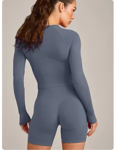 Rückenansicht einer Frau in nahtlosem blauem langärmeligem Sport-Top und Shorts-Set