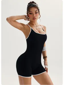Detail view of a black ribbed one-piece yoga bodysuit with white trim on a fitness model