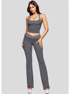 Ganzkörperaufnahme eines grauen Yoga-Sets mit Polka-Dots, Neckholder-Top und Schlaghose