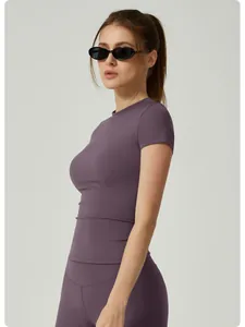 Vista lateral de una camiseta de yoga morada ajustada para mujer en un estudio profesional.