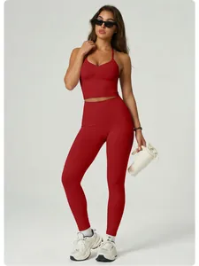 Sporty female model in a red halter yoga set with sunglasses and a white water bottle