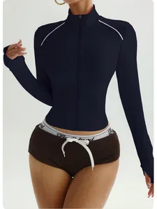 Nahaufnahme der Yoga-Jacke mit weißen Schulterpaspeln und Frontreißverschluss.