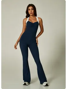 Model wearing navy blue color-block yoga jumpsuit with flared legs and ruched v-neck