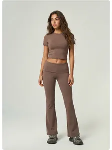 Ganzkörperansicht braunes Yoga-Set mit kurzärmligem Crop-Top und ausgestellter Hose