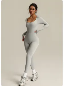 Full-length view of a grey seamless ribbed yoga jumpsuit on a model.