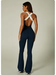 Detailed back view of a navy blue color-block flared yoga jumpsuit with white cross straps.