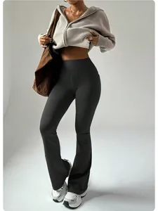 Detail view of black high waisted flared yoga pants with peach lift effect and pockets.