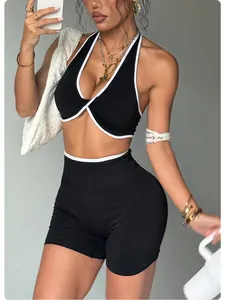 Modella indossa un set da yoga nero senza cuciture con bordi bianchi a contrasto e nodo