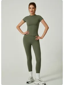 Vue complète d'une femme en ensemble de yoga vert olive à manches courtes et legging.