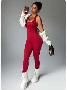 Combinaison dos nu rouge sans couture avec un boléro en tricot blanc et des bottines.