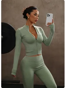 Modella con set yoga verde salvia a coste composto da giacca a maniche lunghe e leggings